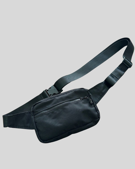 Ultra long belt bag made for plus size people shown in black with a front zipper, top zipper, and discrete back zipper. 